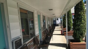 A covered outdoor seating area with rows of chairs and tables, a brick wall, and a Pepsi vending machine.