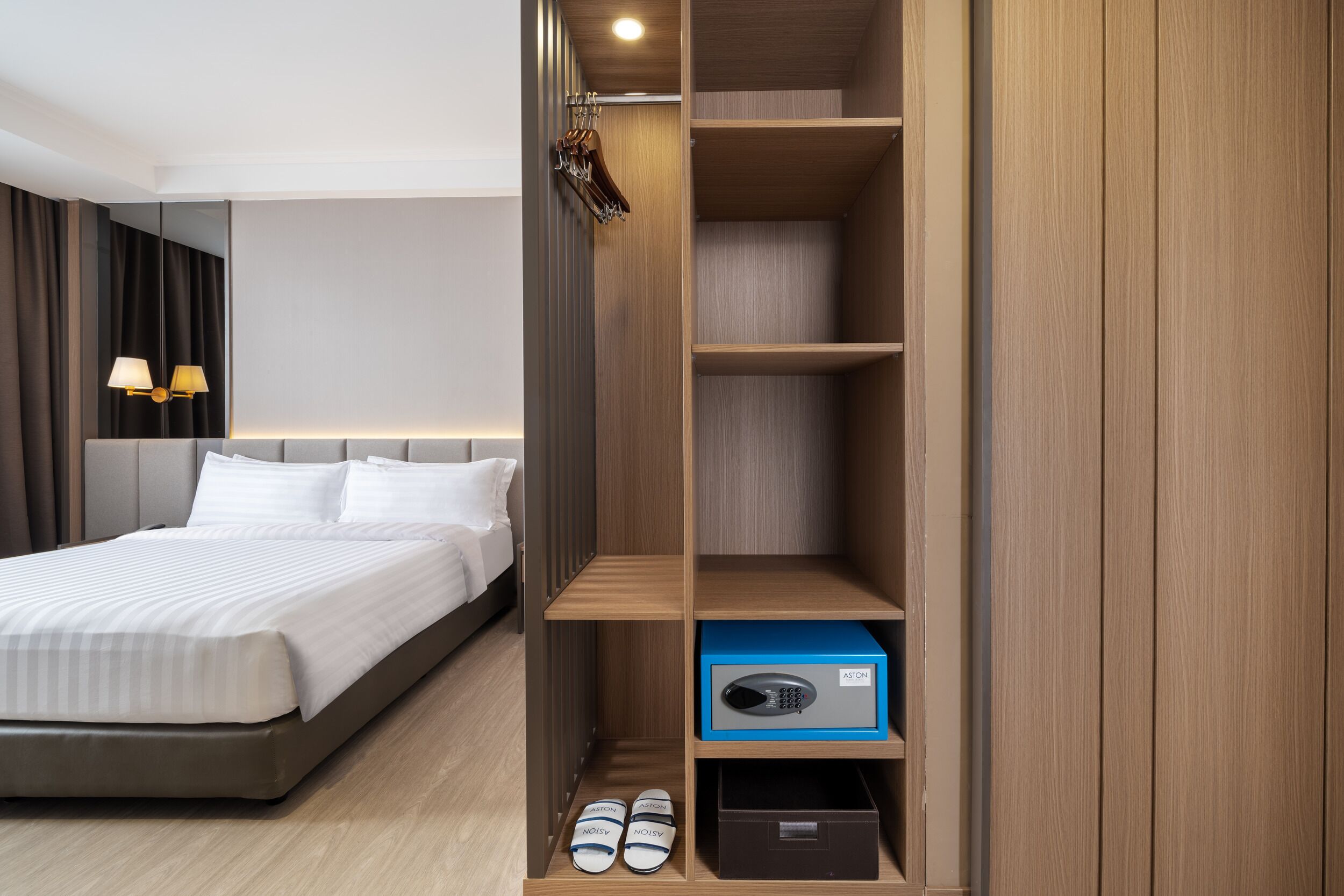 Una habitación de hotel con cama, armario y zapatero.