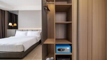 Una habitación de hotel con cama, armario y zapatero.