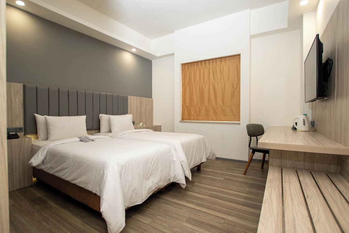 Une chambre d’hôtel moderne, dotée d’un grand lit, d’un bureau et d’une télévision.