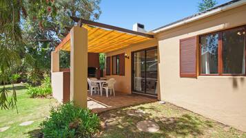 A house with a covered patio, a dining area, and a garden.