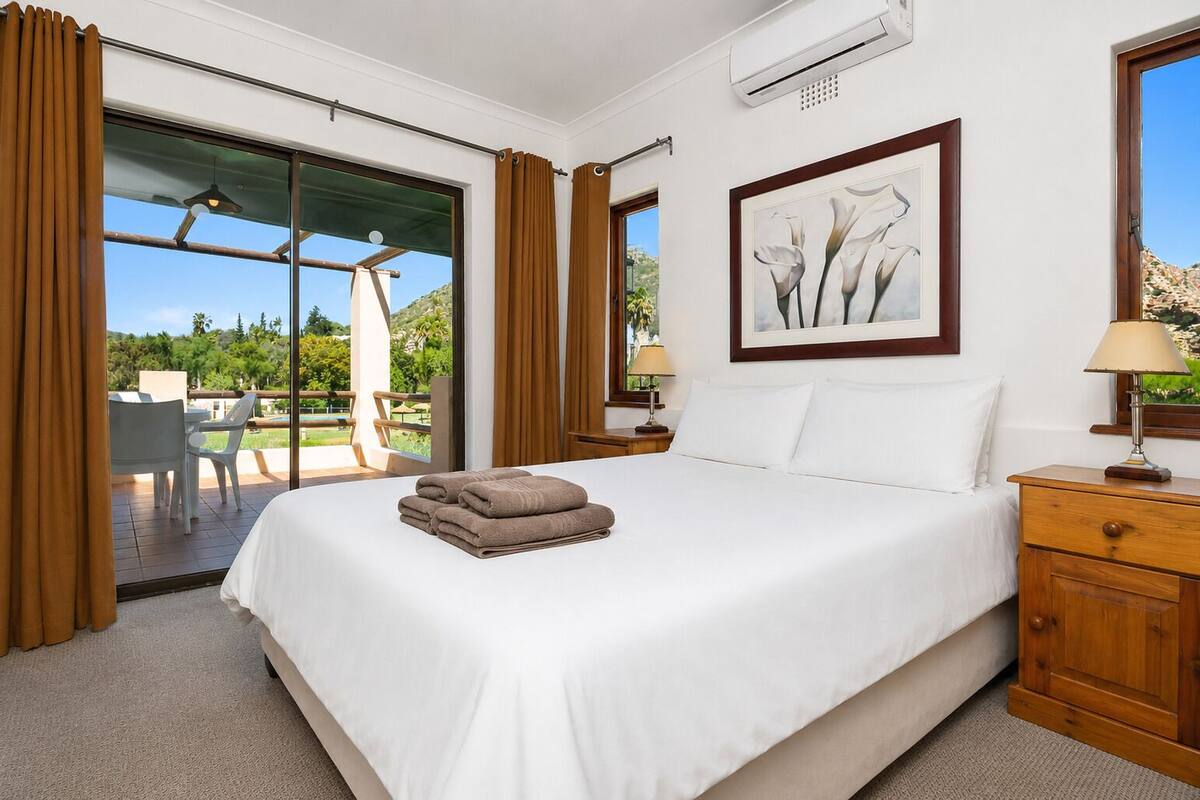 Ein Hotelzimmer mit Bett, Schreibtisch, Stuhl und Blick ins Freie.