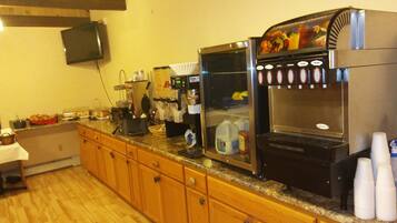 Een keuken met een koffieapparaat, een melkdispenser en een magnetron.