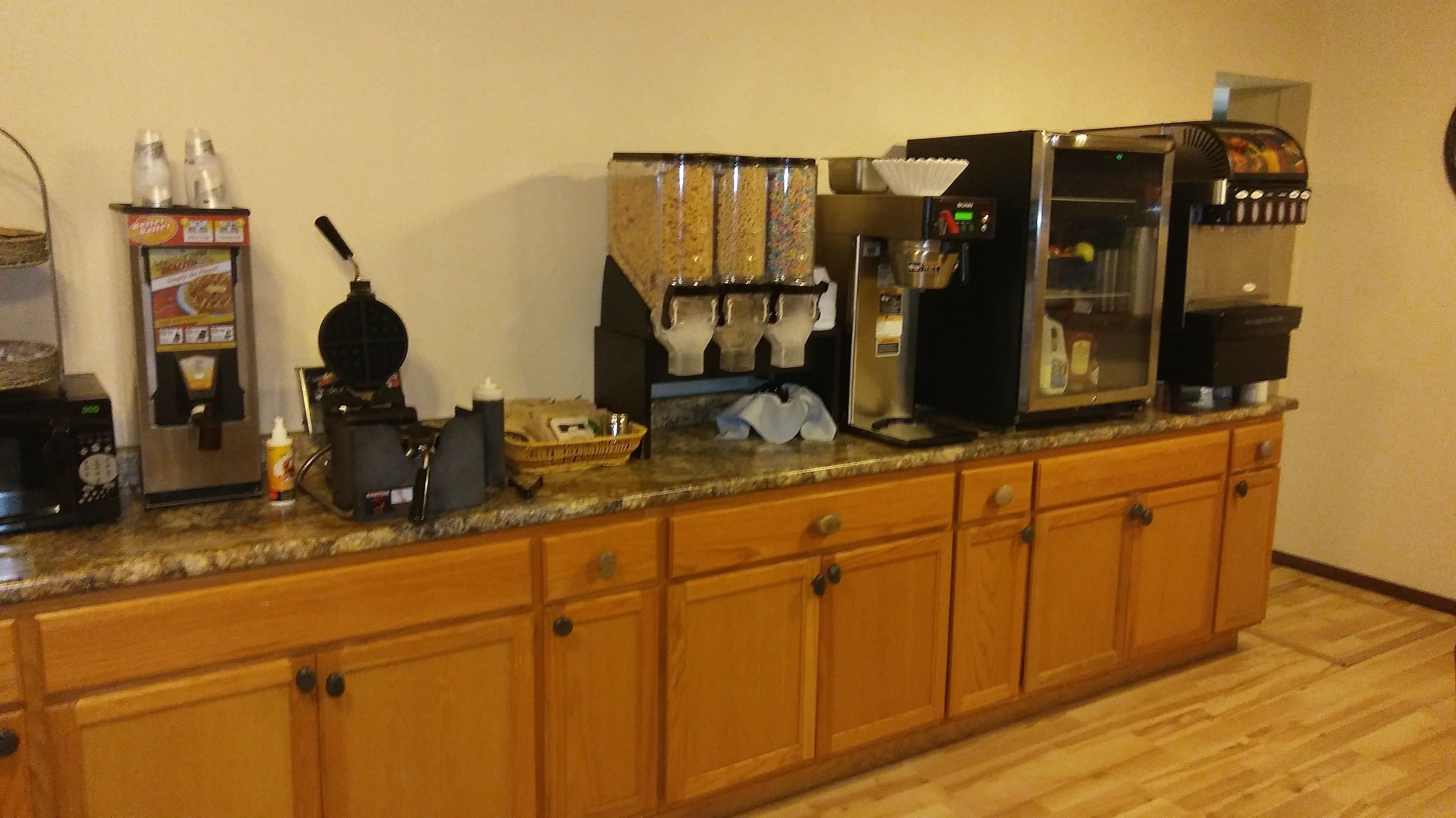 A kitchen counter with various appliances including a coffee maker, a microwave, and a refrigerator.