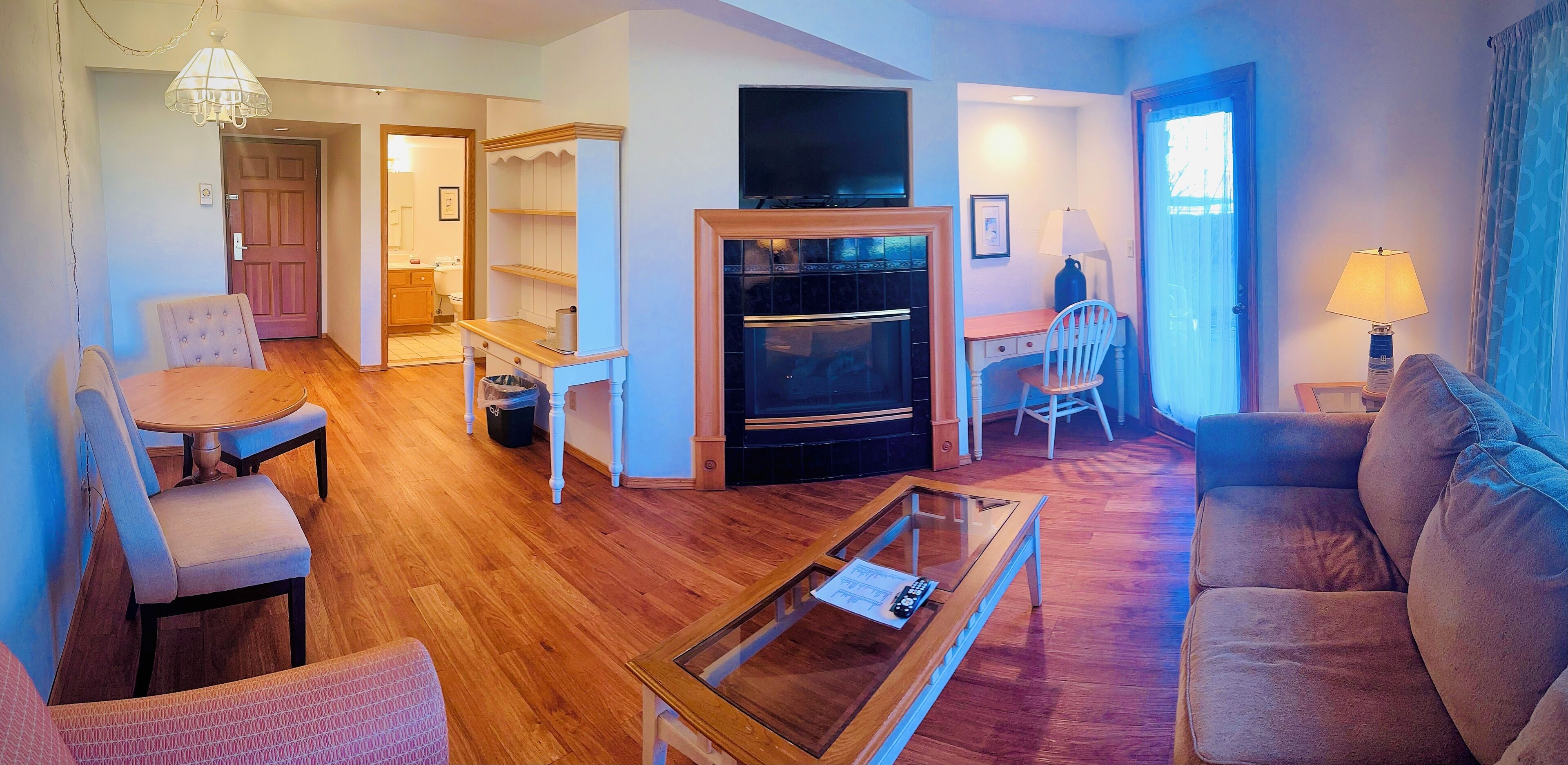 Una sala de estar con sofá, una mesa de centro, televisor y un comedor con sillas y mesa.