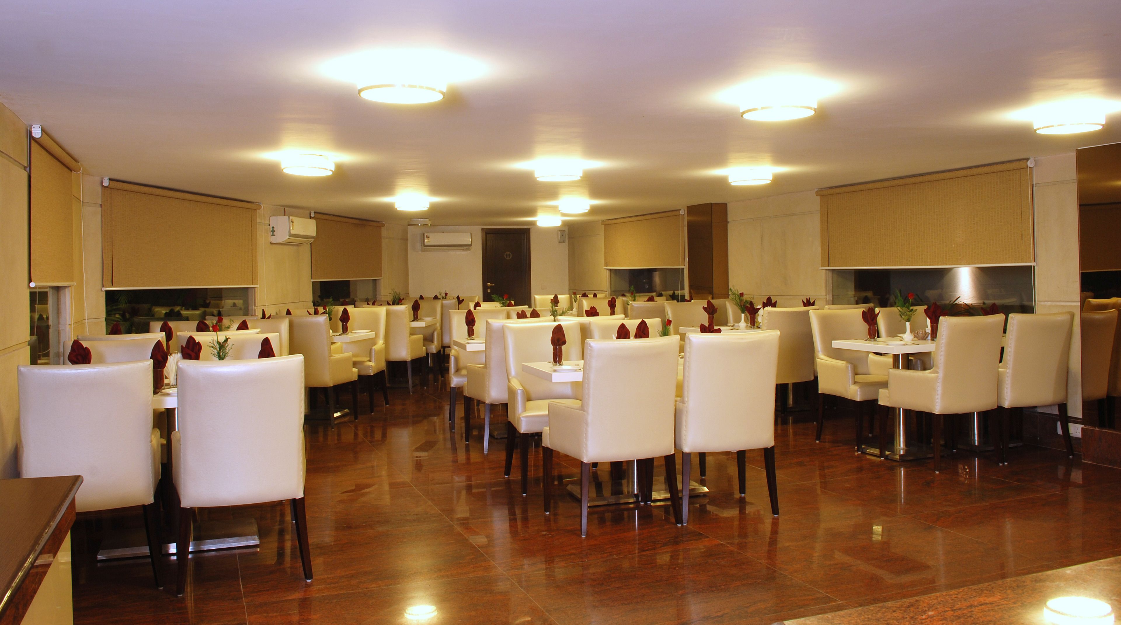 A spacious dining area with multiple tables and chairs, arranged in a modern layout.