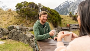 Una mesa de madera en un entorno natural, con montañas al fondo.