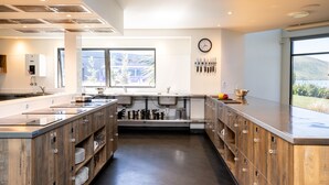 Una cocina moderna con armarios de madera, electrodomésticos de acero inoxidable y un amplio ventanal con vistas al exterior.