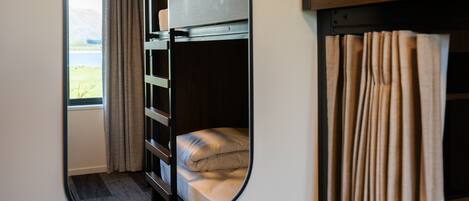 A bunk bed room with a mirror reflecting the interior.