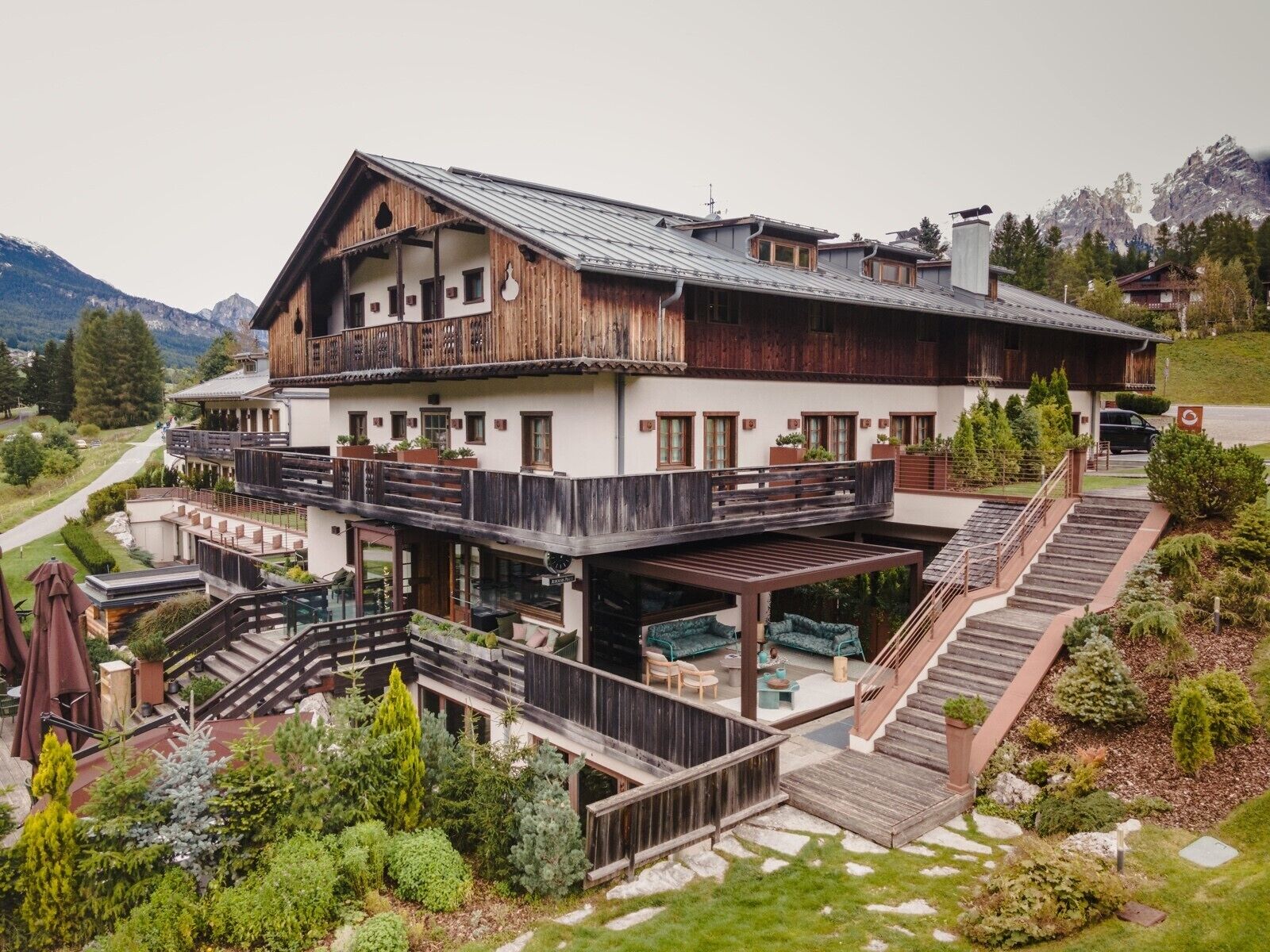 A two-story chalet with a wooden exterior, balconies, and a covered outdoor seating area.