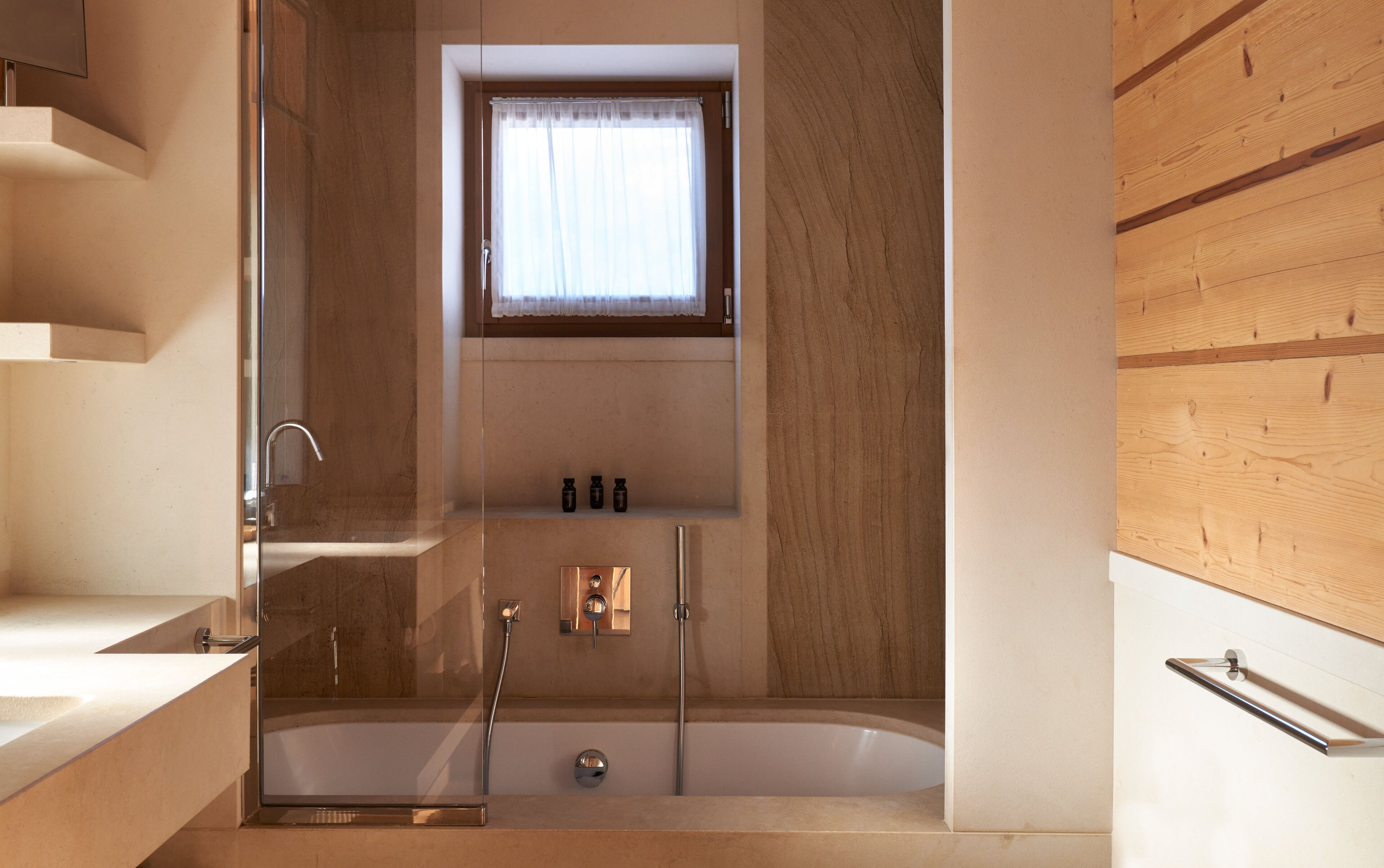 Un baño moderno con bañera, ducha y ventana con cortina.