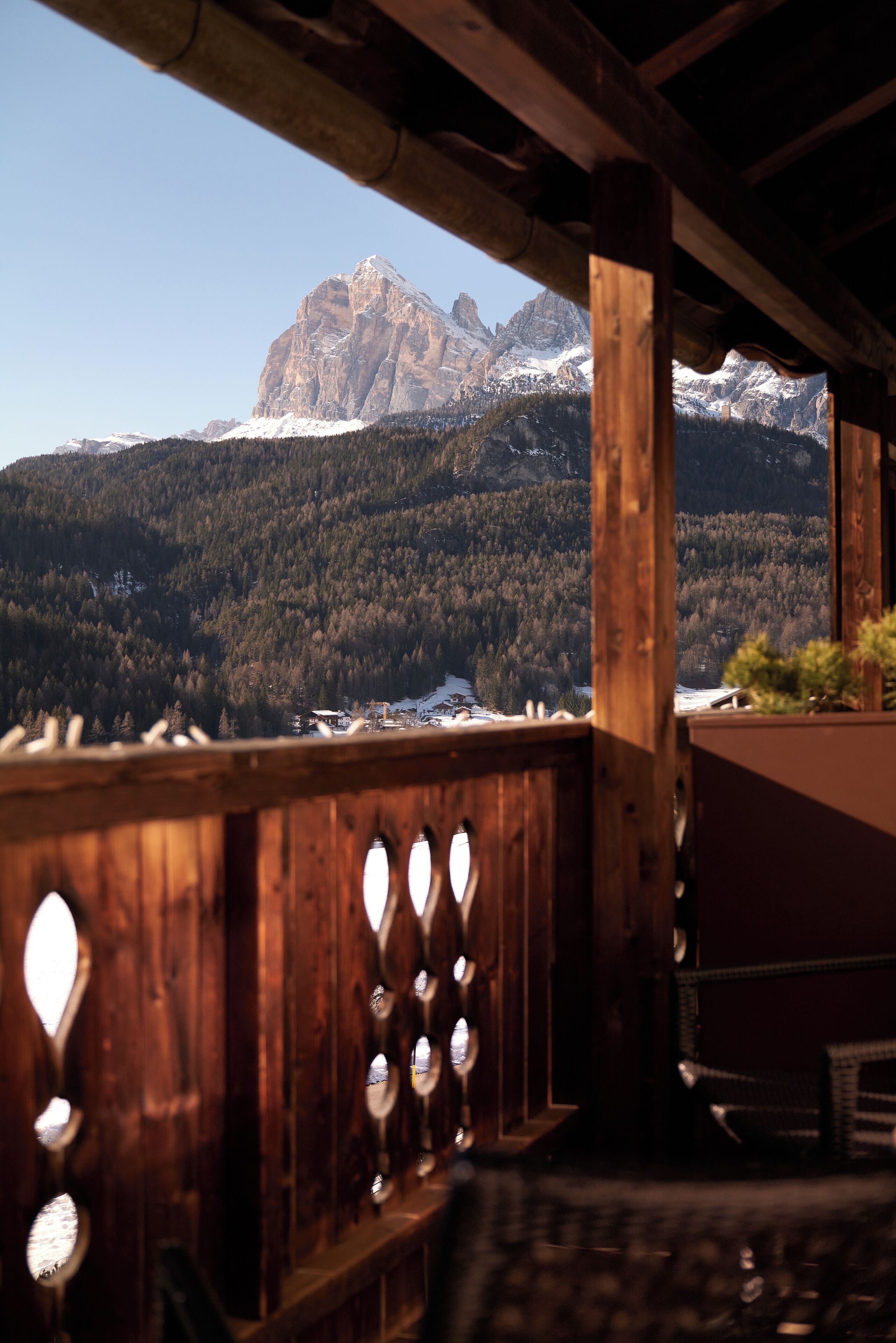 Un balcón de madera con vistas a una cadena montañosa.