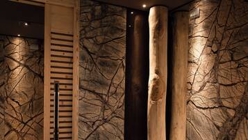 A modern bathroom with a freestanding bathtub, wooden accents, and a textured wall.