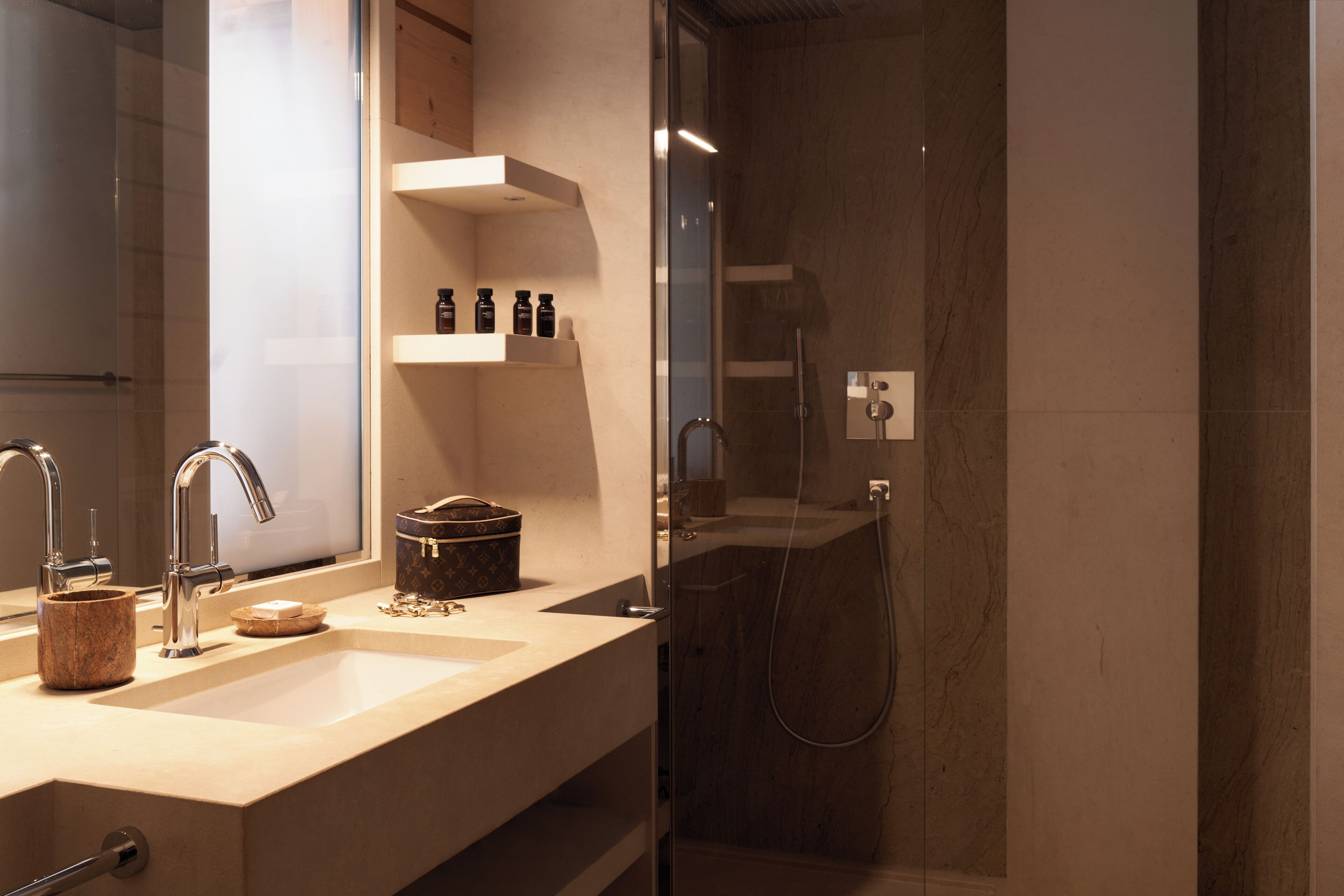 Une salle de bain moderne avec une douche à parois de verre, un comptoir beige et un miroir de coiffeuse.