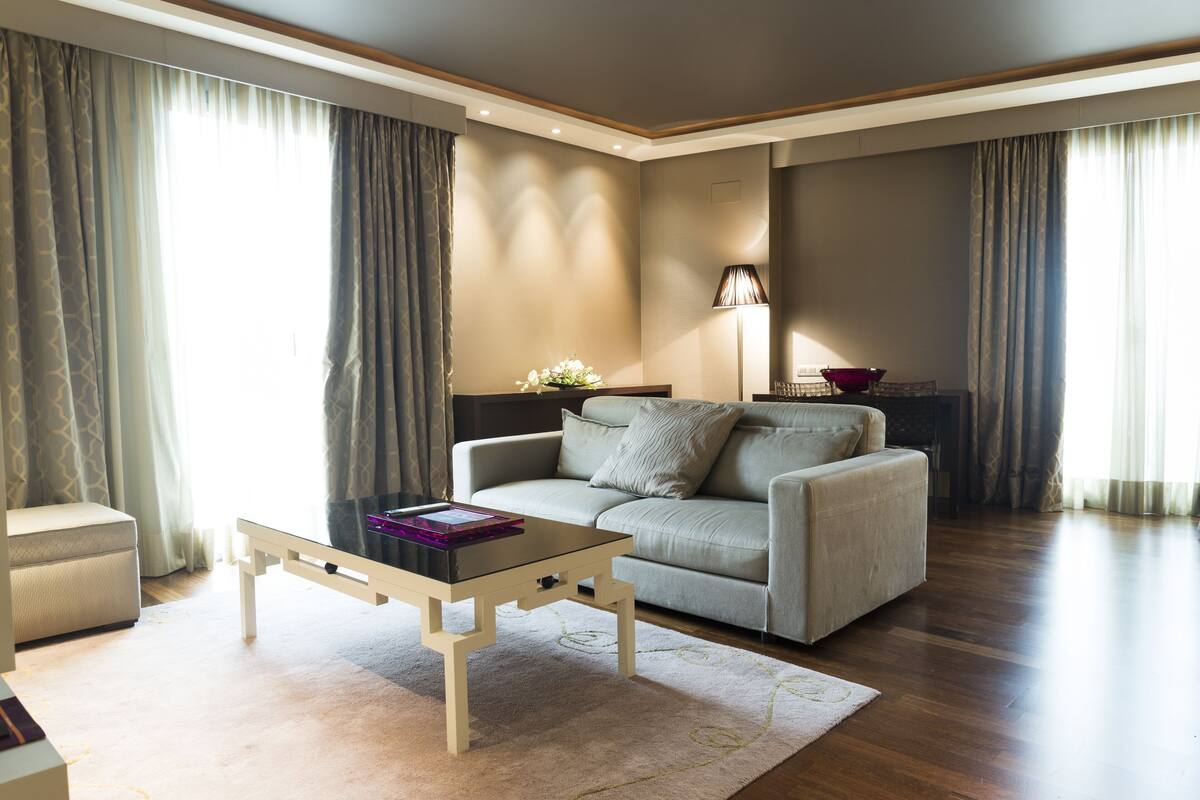 Un salon moderne avec un canapé, une table basse et une lampe.