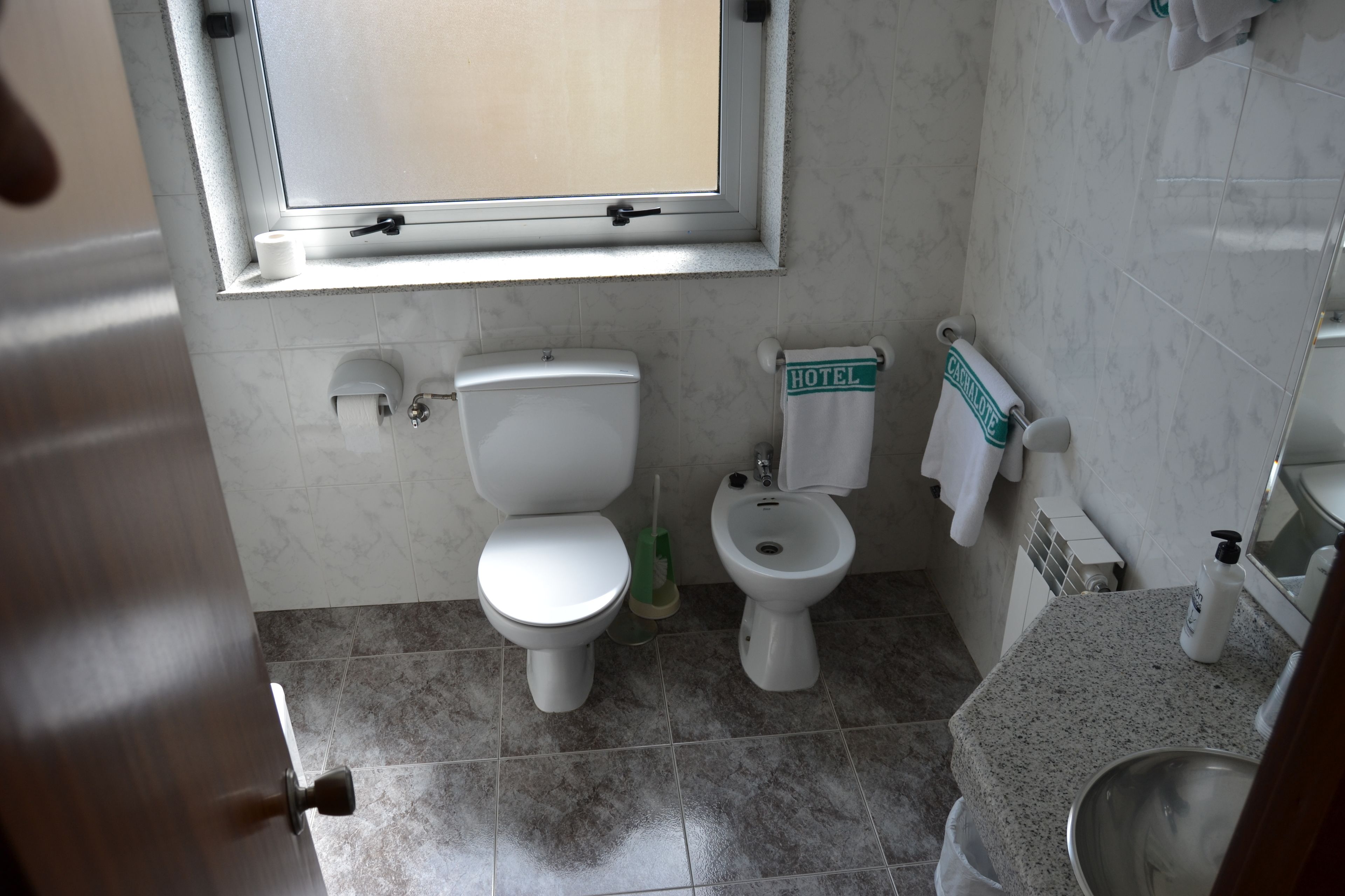 Un baño con inodoro, bidé y lavamanos.