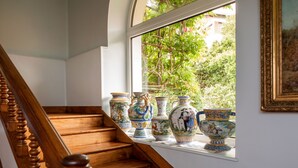 A staircase with wooden railings and a window with decorative vases. - Casa Rural Mailan (Aia)