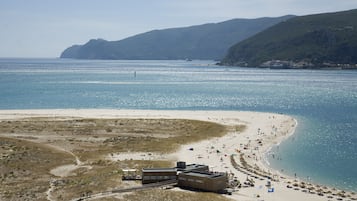 Aan het strand, wit zand, parasols, een strandbar