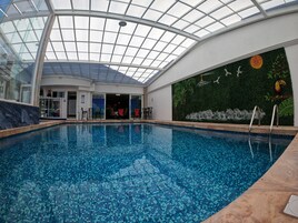 Una piscina techada, sillones reclinables de piscina