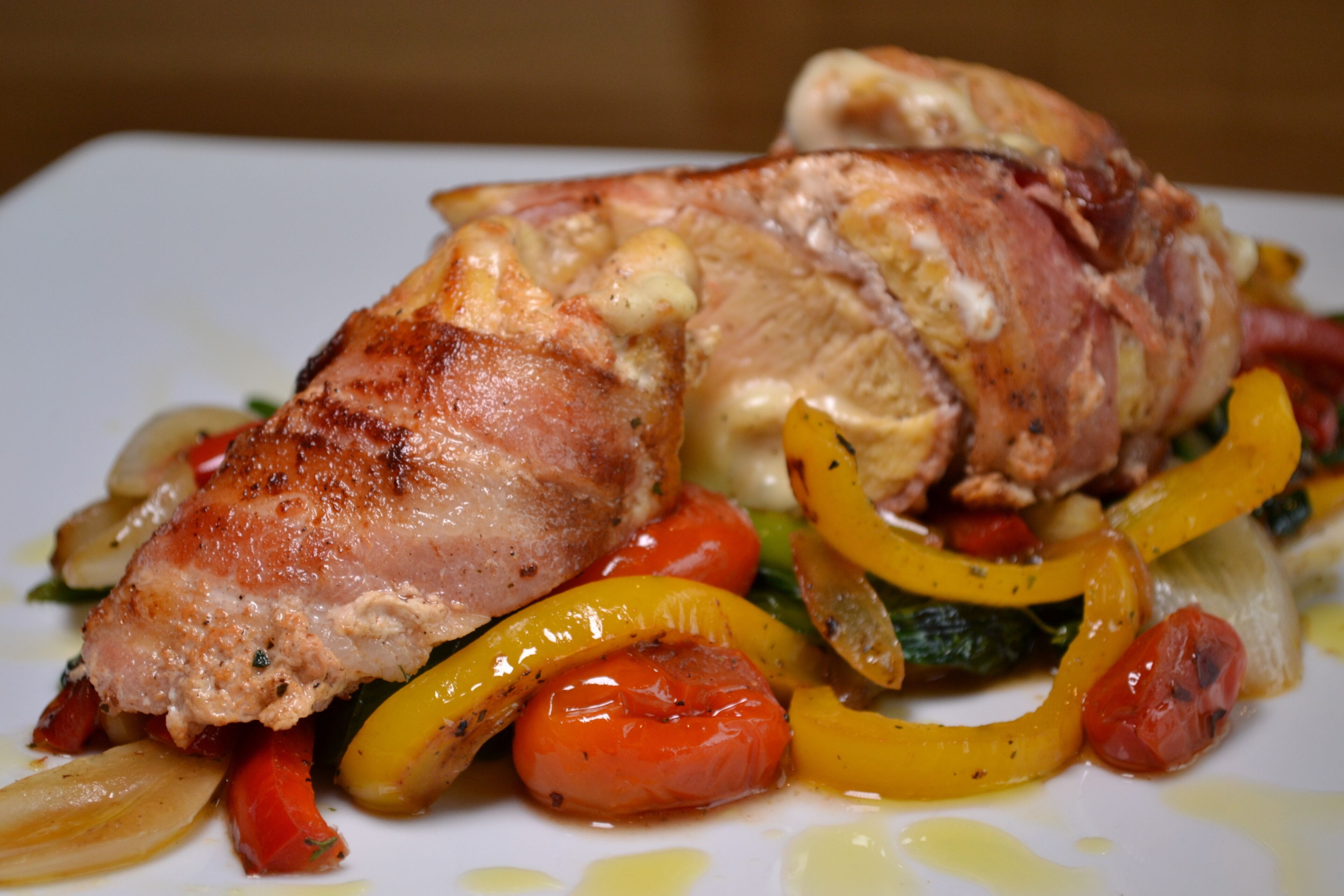 A dish with roasted meat, vegetables, and a sauce.