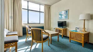 A hotel room with a bed, a desk, a chair, a TV, and a lamp. - Gardens Centre Holiday Apartments (Cape Town)