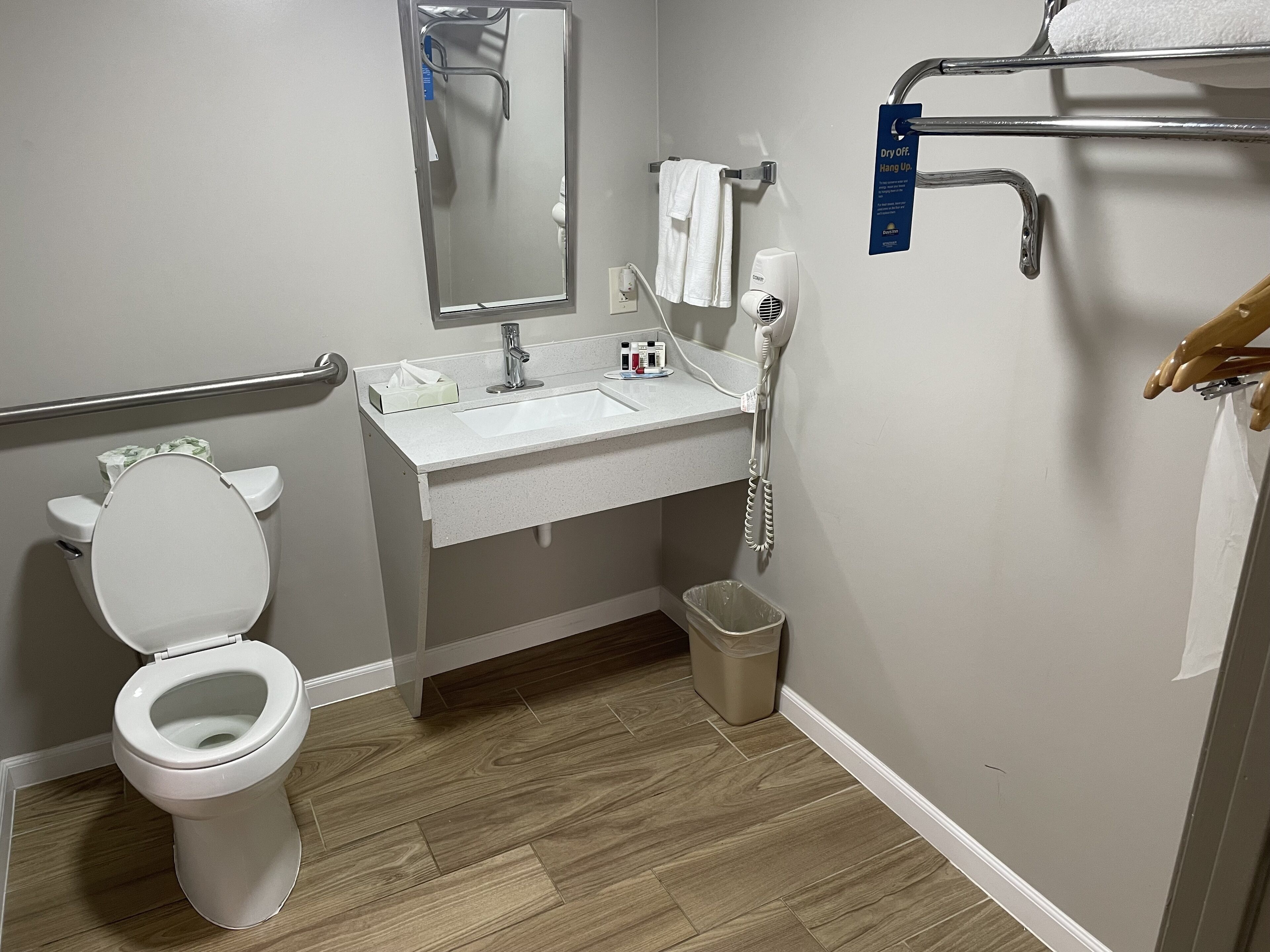 A modern bathroom with a toilet, sink, and hand dryer.