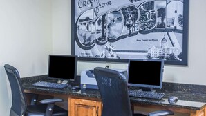 A computer desk with two monitors, a keyboard, and a mouse. There is a framed picture of Valdosta, Georgia on the wall behind the desk. - Days Inn by Wyndham Valdosta/Near Valdosta Mall (Valdosta)