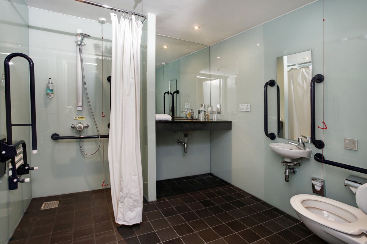 A modern bathroom with a shower, toilet, and sink.