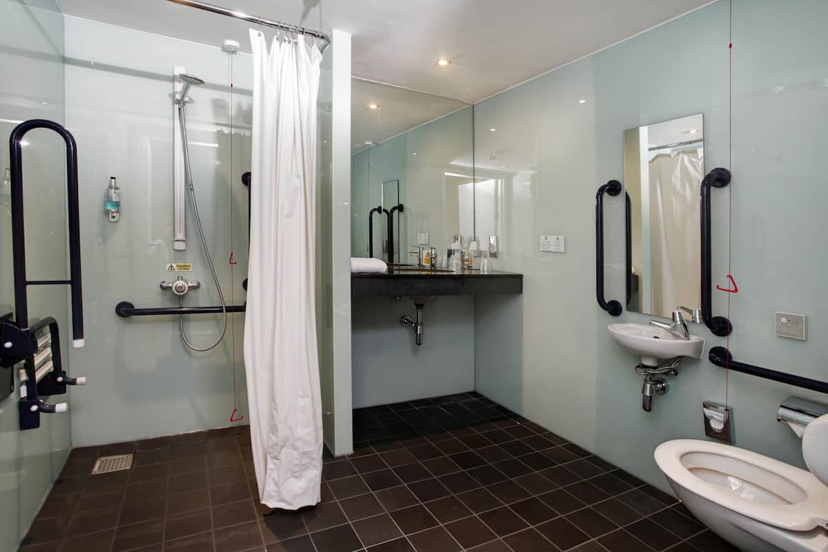 A modern bathroom with a shower, toilet, and sink.