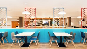A modern bar area with a counter, seating, and a television screen. - Holiday Inn London - Luton Airport by IHG (Luton)