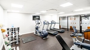 A gym with treadmills, elliptical machines, and weightlifting equipment.