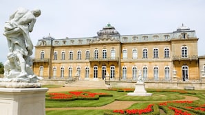 A grand building with a symmetrical facade, multiple windows, and a central staircase leading to the entrance.