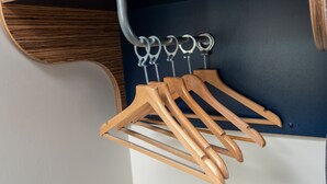 A wooden coat rack with multiple hangers against a dark wall. - go2 portishead marina hotel (Bristol)