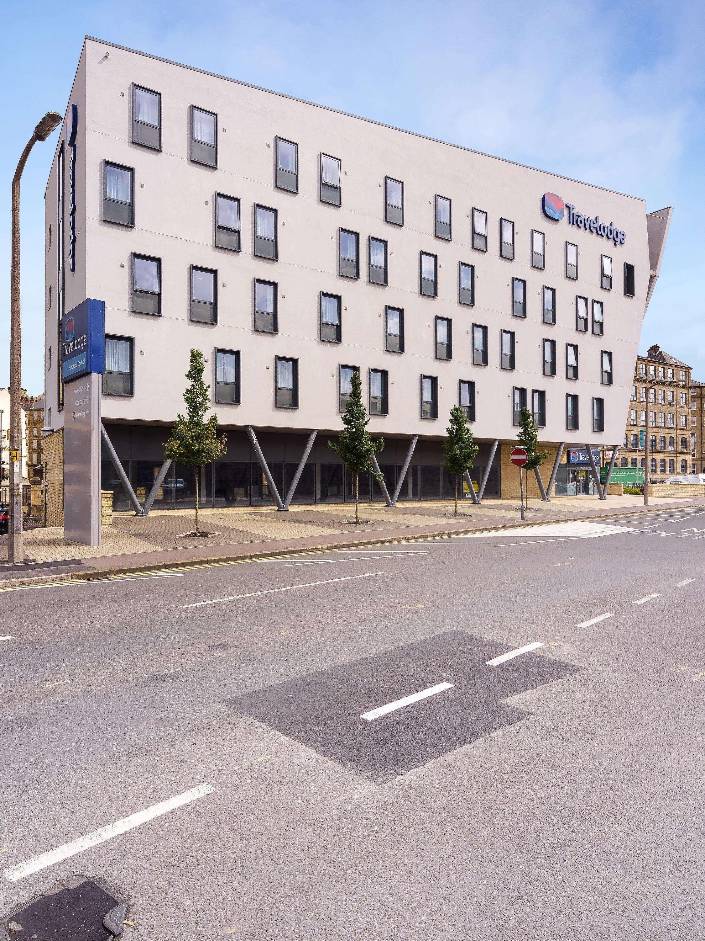 A Travelodge hotel with a modern facade, multiple windows, and a clear sky.