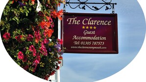 Un letrero para The Clarence Guest Accommodation con información de contacto y una dirección web.