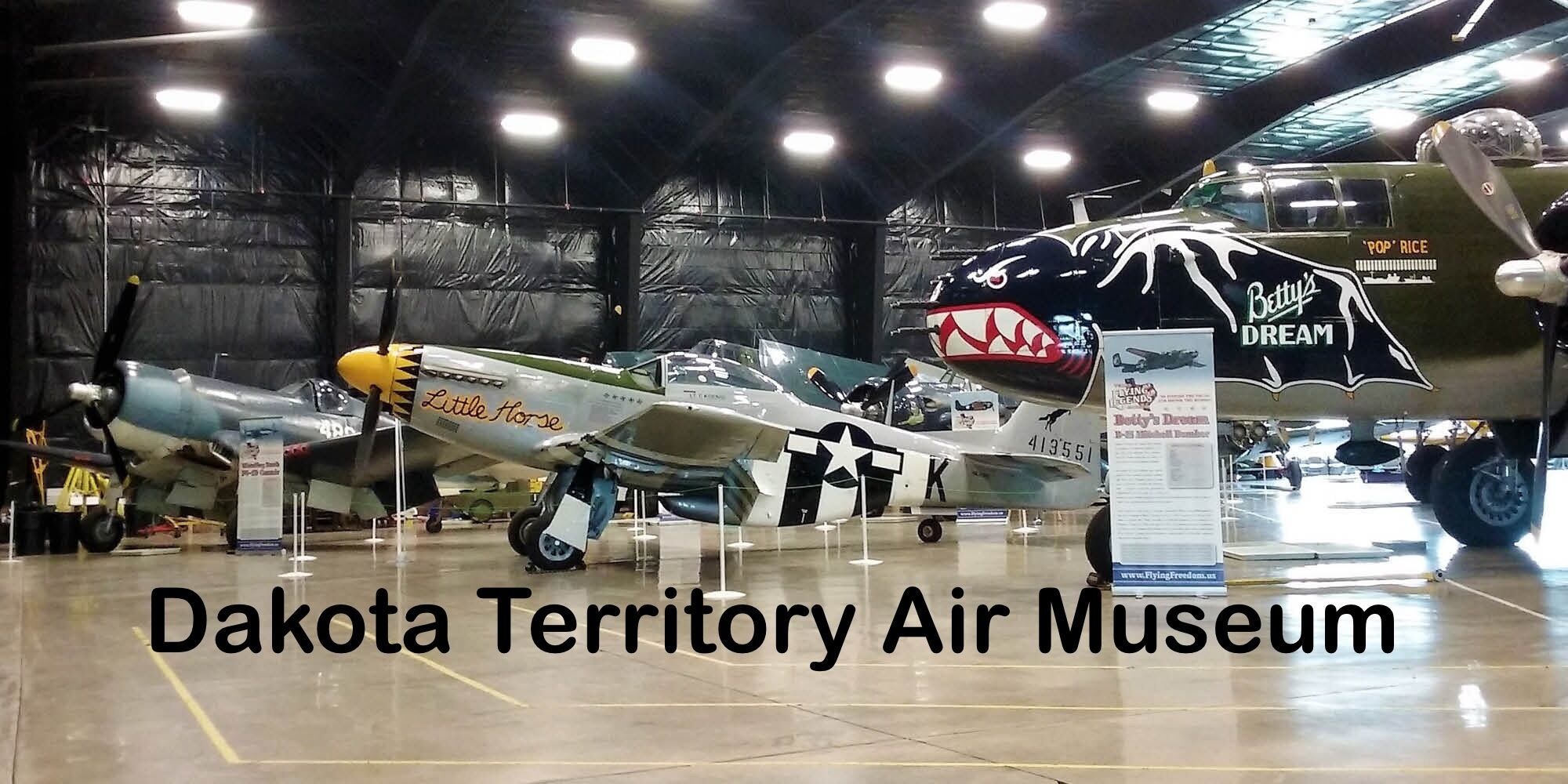 An air museum with various aircraft on display, including a notable fighter plane with a distinctive shark mouth design.