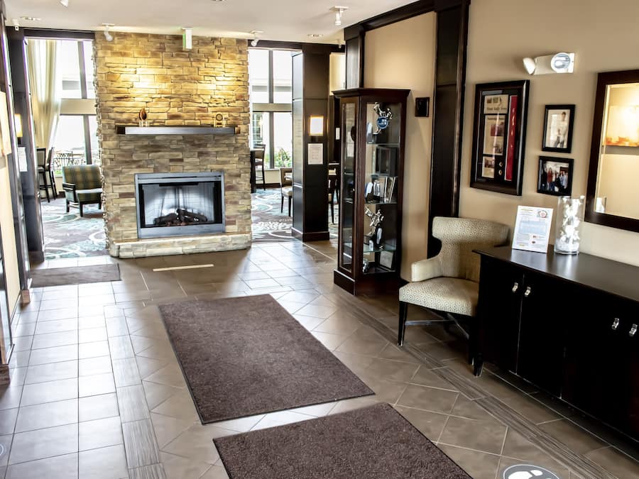 A spacious living area with a stone fireplace, a glass display cabinet, and a comfortable seating area.