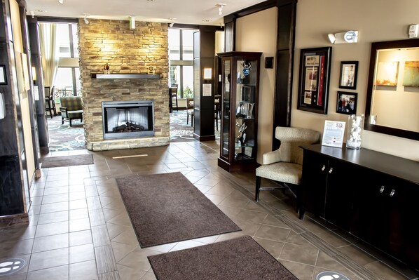 A spacious living area with a stone fireplace, a glass display cabinet, and a comfortable seating area.
