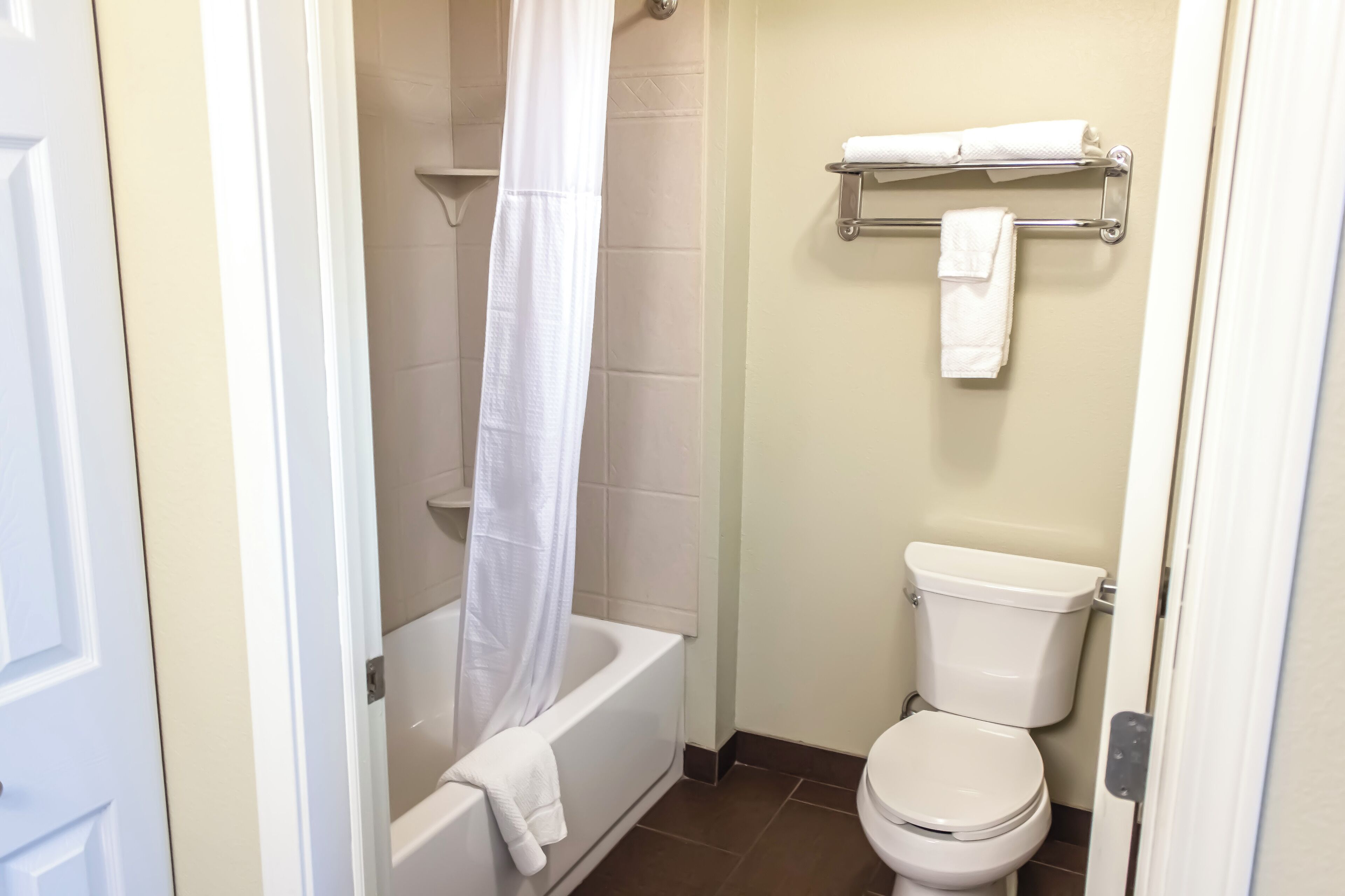A bathroom with a bathtub, toilet, and towel rack.