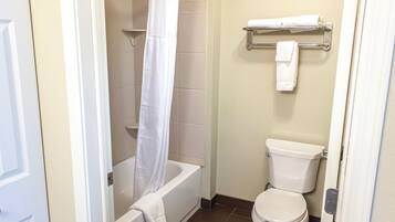 A bathroom with a bathtub, toilet, and towel rack.