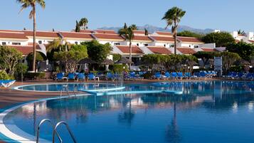 Een buitenzwembad, parasols voor strand/zwembad