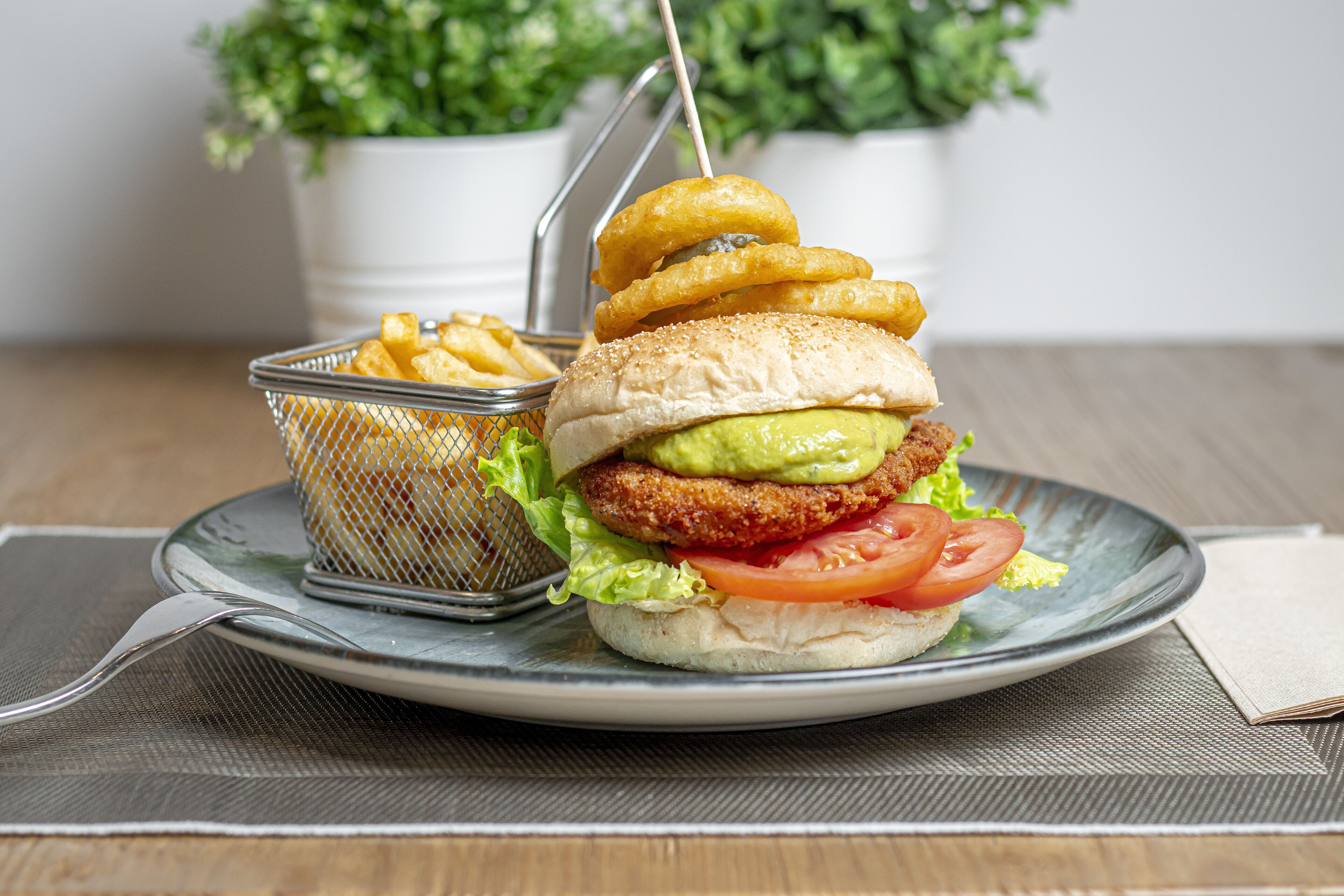 A plate with a burger, fries, and onion rings.