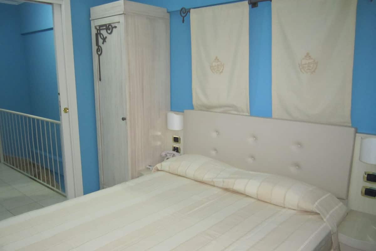 A bedroom with a bed, a wardrobe, and a bathroom.
