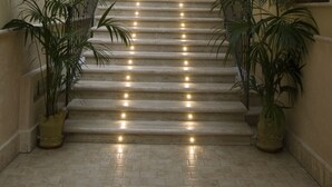 A staircase with multiple steps, flanked by potted plants and a light fixture above. - Palazzo Reginella Residence Hotel (Bovalino)
