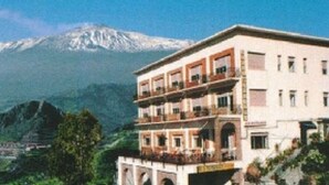 Un hôtel à plusieurs étages, doté de balcons, situé dans un cadre montagneux.