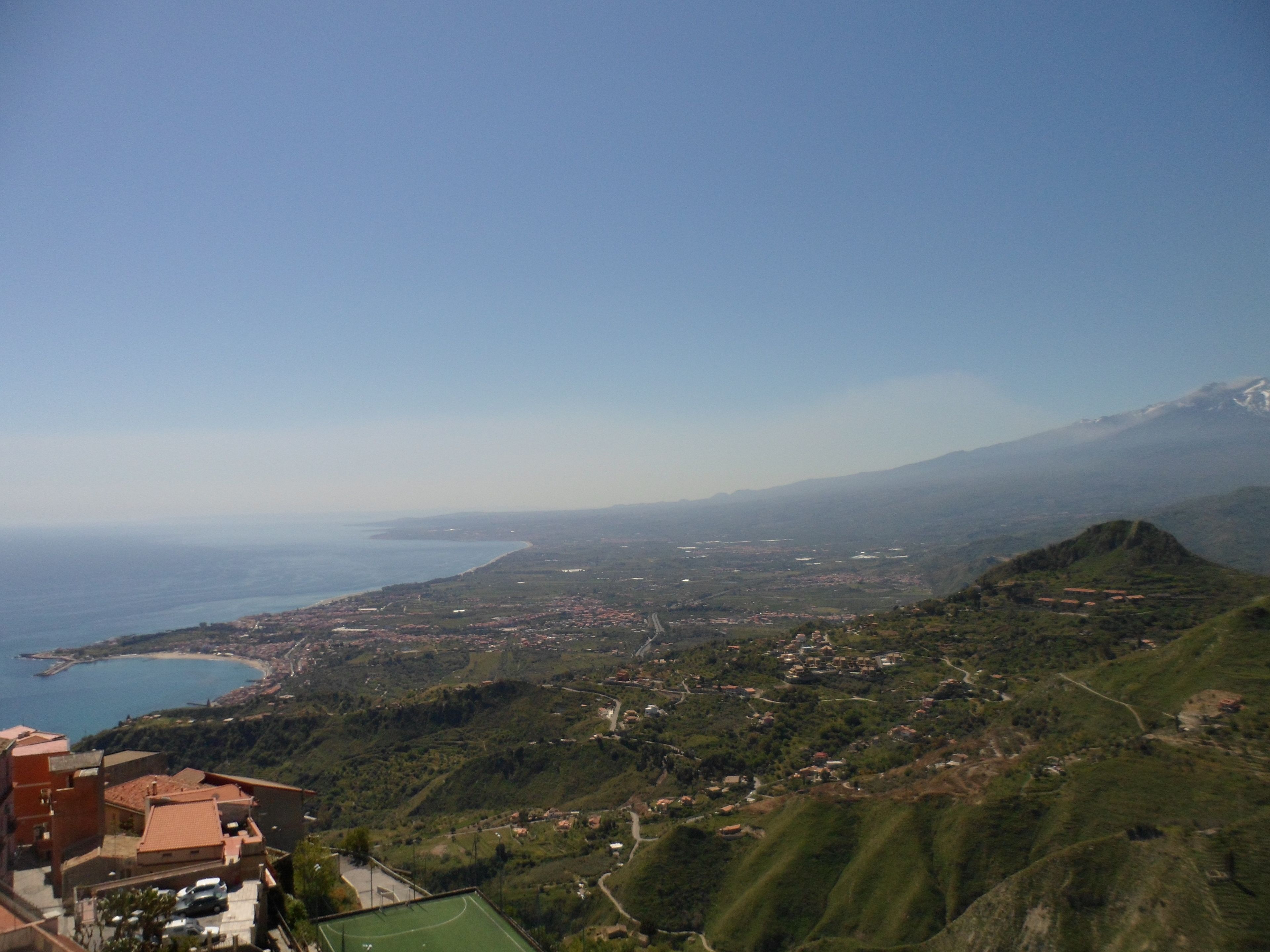 Eine Küstenstadt mit Blick auf das Meer und einem Berg im Hintergrund.