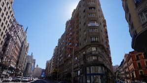 A tall, multi-story building with balconies and a sign indicating it is a school.