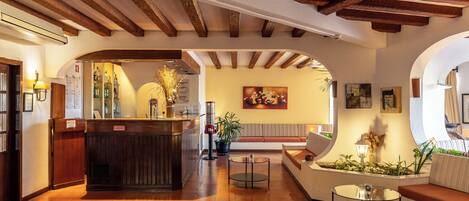 A lobby with a reception desk, seating area, and a wall with artwork.