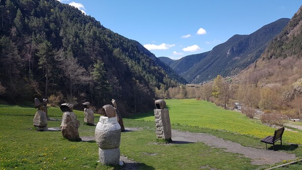 A stone circle in a grassy field with mountains in the background. - Hotel Sucarà (La Cortinada)