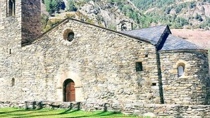 A stone church with a bell tower, arched windows, and a small bell. - Hotel Sucarà (La Cortinada)